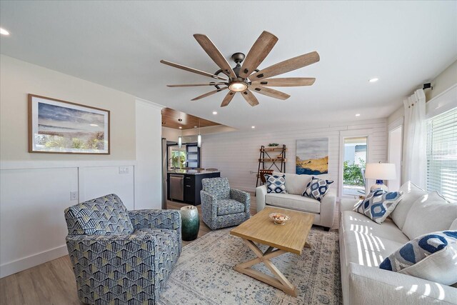 living room with light hardwood / wood-style floors and ceiling fan