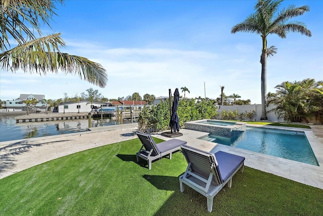 view of swimming pool with a yard, a water view, and an in ground hot tub