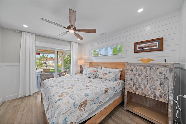 bedroom featuring access to exterior, light hardwood / wood-style flooring, and ceiling fan