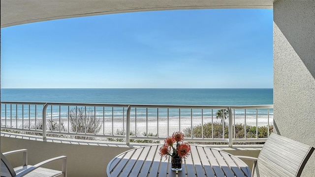 balcony featuring a view of the beach and a water view