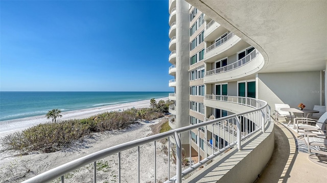 balcony with a water view and a beach view