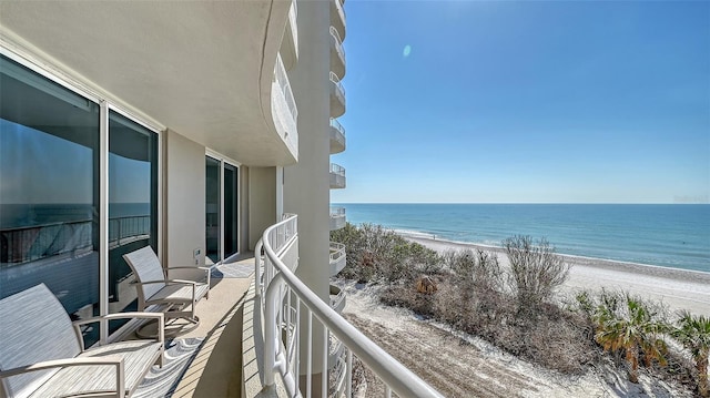 balcony featuring a water view and a beach view