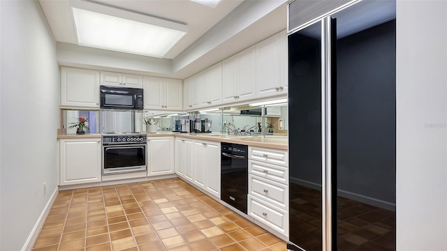 kitchen featuring white cabinetry, light tile patterned flooring, and black appliances