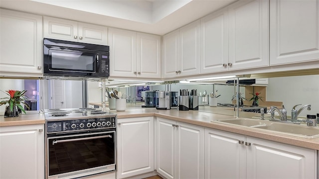 kitchen featuring range with electric cooktop, sink, and white cabinets