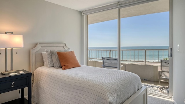 bedroom with a water view and a view of the beach