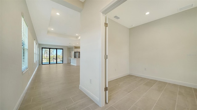 corridor featuring a raised ceiling