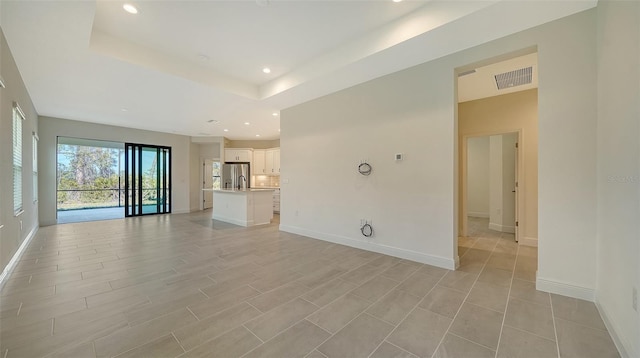 unfurnished living room with a raised ceiling