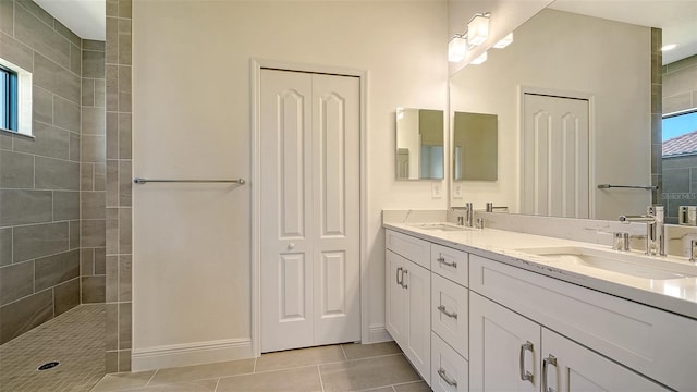 bathroom featuring tile patterned flooring, vanity, and tiled shower