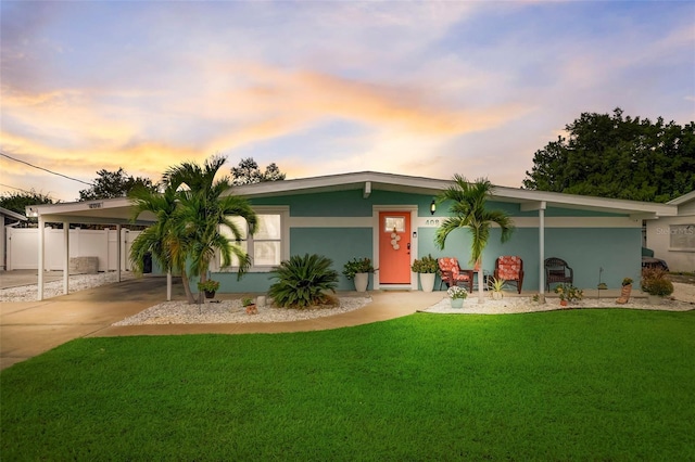 mid-century inspired home with fence, driveway, a front lawn, and stucco siding