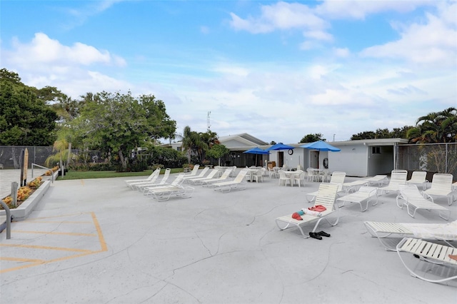 view of property's community featuring fence and a patio