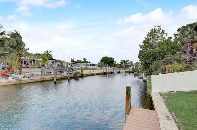 view of dock with a water view and fence