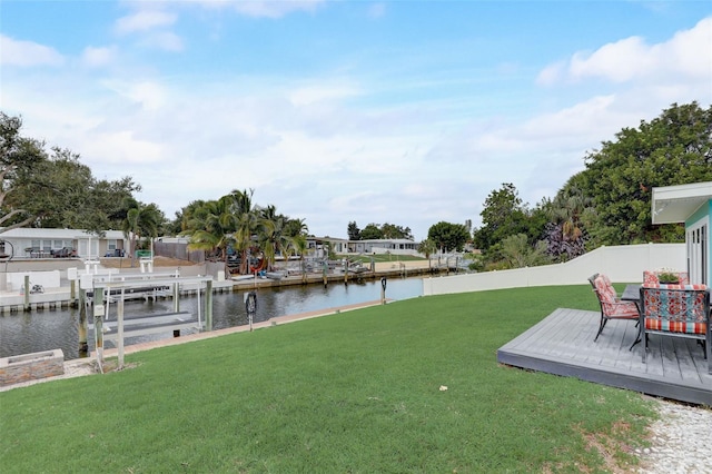 view of yard with a water view, a boat dock, and fence