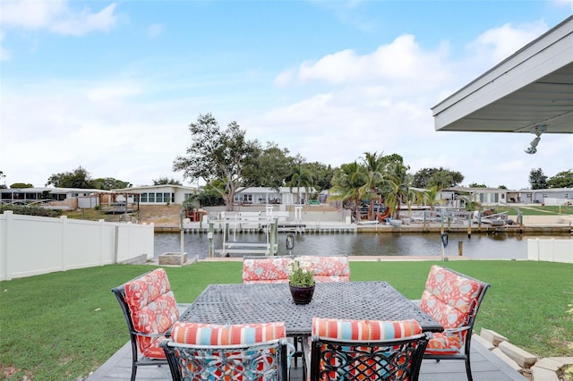 view of patio / terrace with outdoor dining area, a water view, fence, and a boat dock