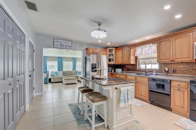 kitchen featuring appliances with stainless steel finishes, decorative backsplash, a sink, and light tile patterned flooring