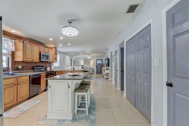 kitchen with a peninsula, black appliances, visible vents, and light tile patterned flooring