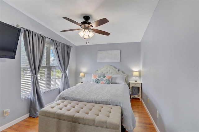 bedroom with light wood-style floors, ceiling fan, and baseboards