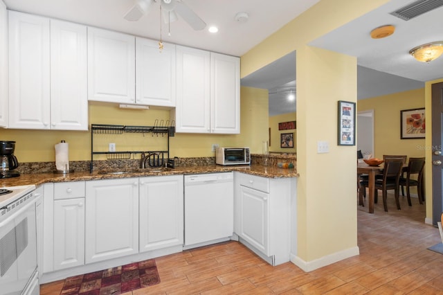 kitchen featuring white cabinetry, sink, dark stone countertops, white appliances, and light hardwood / wood-style flooring