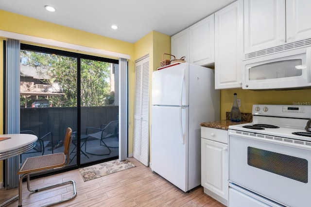 kitchen with white cabinetry, white appliances, dark stone counters, and light hardwood / wood-style flooring