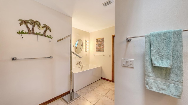 bathroom featuring baseboards, a tub to relax in, visible vents, and tile patterned floors