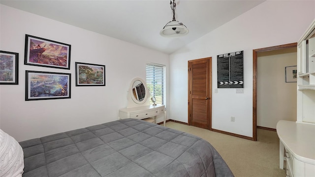 bedroom featuring lofted ceiling, baseboards, a closet, and light colored carpet