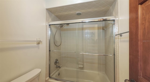 bathroom featuring enclosed tub / shower combo and toilet