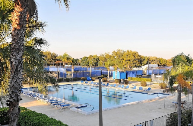 community pool with fence and a patio