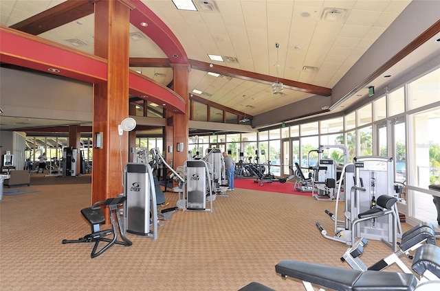 workout area featuring carpet, visible vents, and high vaulted ceiling