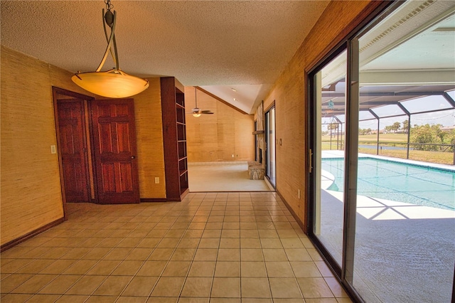 3837 Torrey Pines Blvd, Sarasota, FL 34238 - corridor with vaulted ceiling, a textured ceiling, wooden walls, light tile patterned flooring, and baseboards