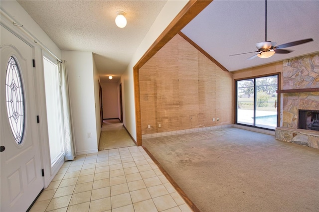 3837 Torrey Pines Blvd, Sarasota, FL 34238 - foyer entrance featuring a textured ceiling, light colored carpet, a fireplace, baseboards, and light tile patterned floors