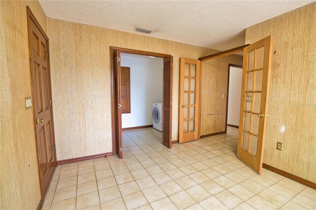 3837 Torrey Pines Blvd, Sarasota, FL 34238 - unfurnished room featuring french doors, a textured ceiling, wallpapered walls, washer / clothes dryer, and baseboards