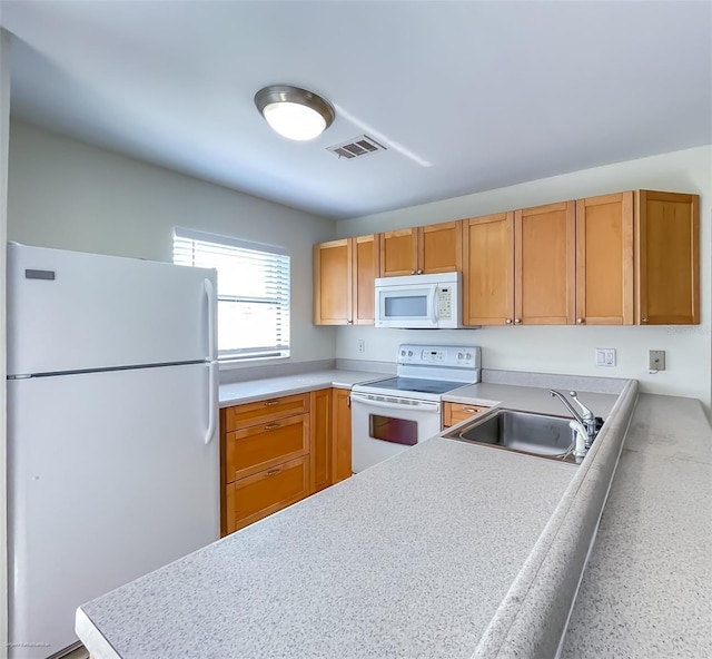 kitchen with white appliances, kitchen peninsula, and sink