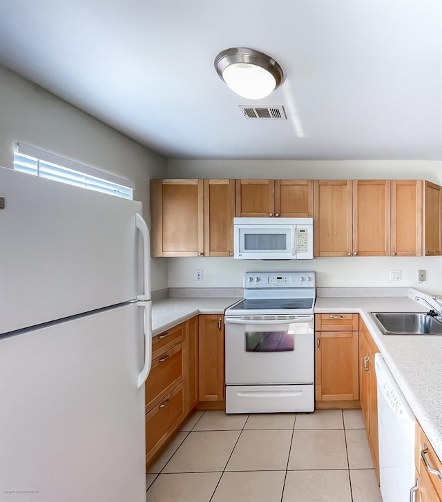 kitchen with white appliances, sink, and light tile patterned floors