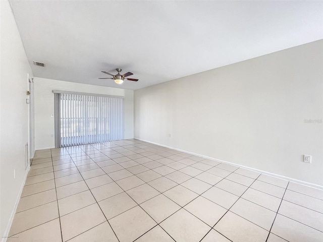 tiled spare room featuring ceiling fan