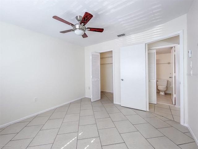 unfurnished bedroom with light tile patterned floors, ceiling fan, and a closet