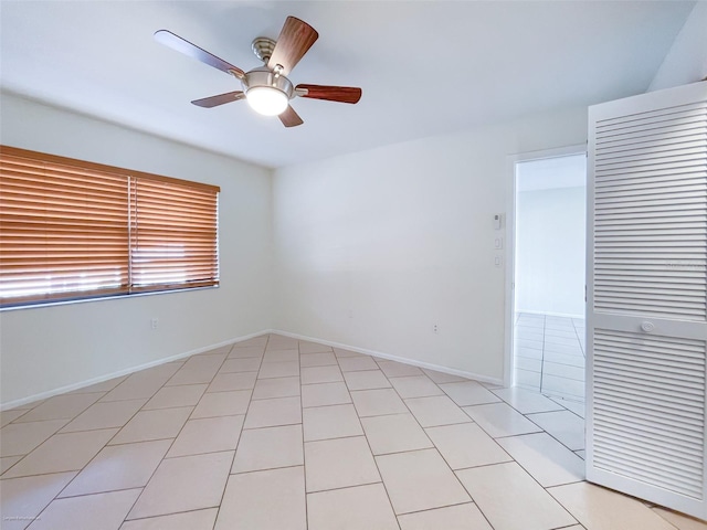 tiled empty room featuring ceiling fan