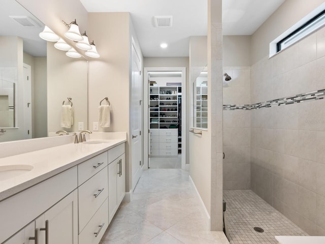 bathroom featuring tiled shower and vanity