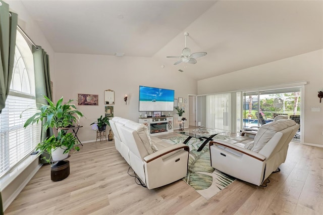 living room with a fireplace, vaulted ceiling, light hardwood / wood-style floors, and ceiling fan