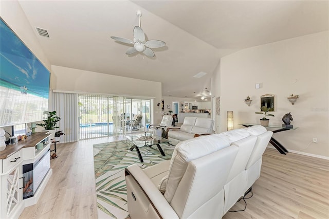 living room with light hardwood / wood-style flooring, high vaulted ceiling, and ceiling fan