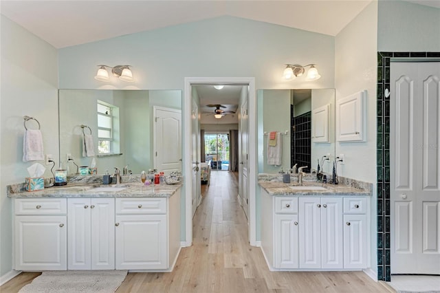 bathroom featuring vanity, lofted ceiling, hardwood / wood-style floors, and ceiling fan