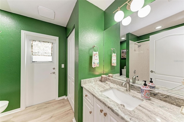 bathroom featuring vanity, hardwood / wood-style flooring, and toilet