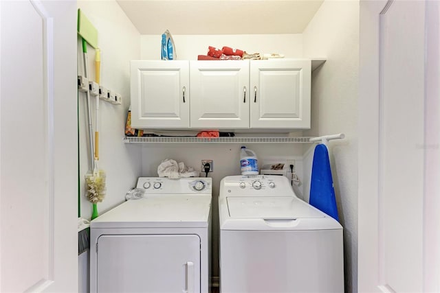 laundry room featuring cabinets and washing machine and dryer