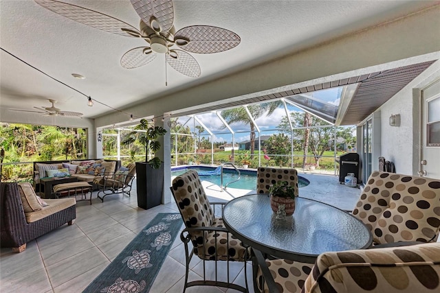 view of patio with an outdoor living space, ceiling fan, and glass enclosure