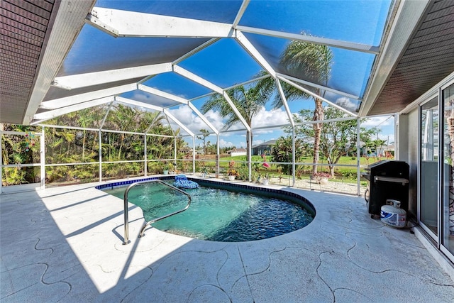 view of pool with area for grilling, a patio area, and glass enclosure