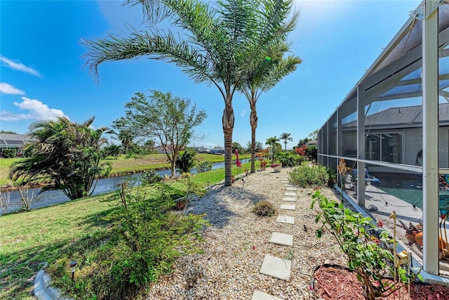 view of yard featuring a water view and glass enclosure