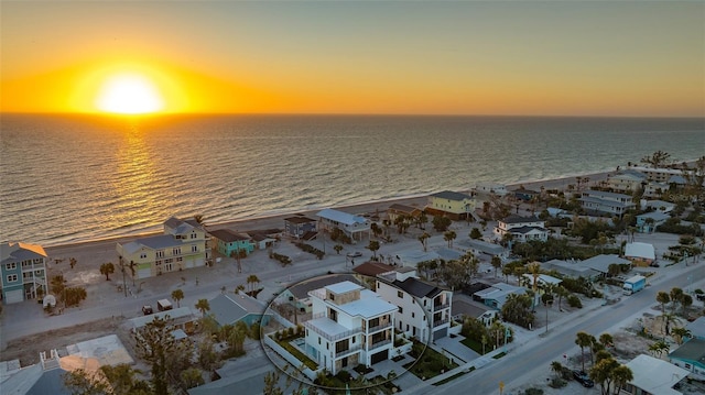 aerial view at dusk featuring a water view