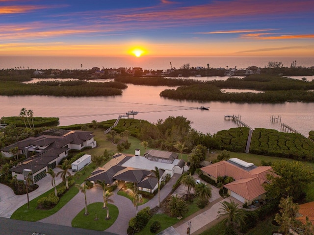 aerial view at dusk featuring a water view