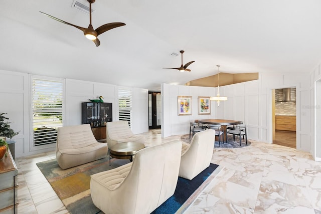 living room featuring ceiling fan, plenty of natural light, and vaulted ceiling