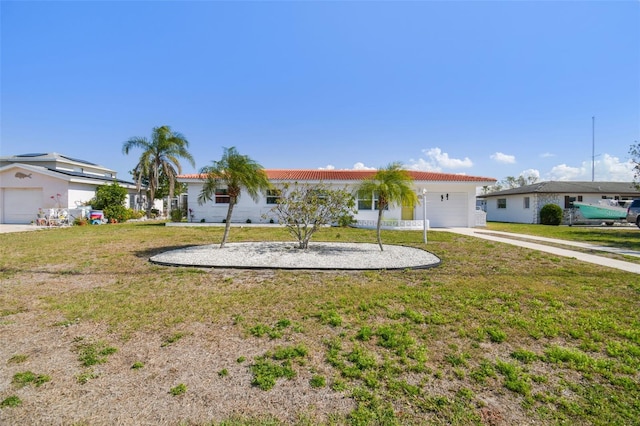 ranch-style home featuring a garage and a front lawn