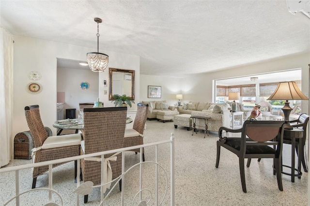 dining area featuring a notable chandelier and a textured ceiling