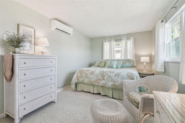 bedroom featuring a wall mounted air conditioner and a textured ceiling